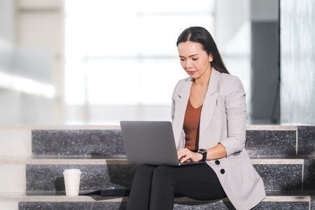 Matured businesswoman prepares report on laptop outside meeting before business meetingの写真素材