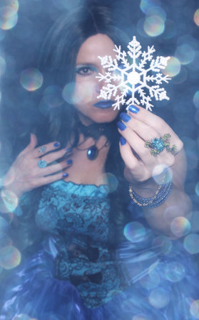 Woman with snowflake ornament and blue bokehの写真素材