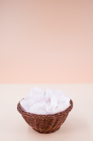 hibiscus flowers in a wicker canister on a beige background with text spaceの写真素材