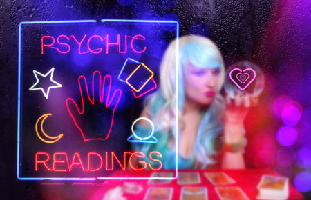 Tarot Card Readings Neon Sign in Window with Psychic Tarot Card Reader blurred in backgroundの写真素材
