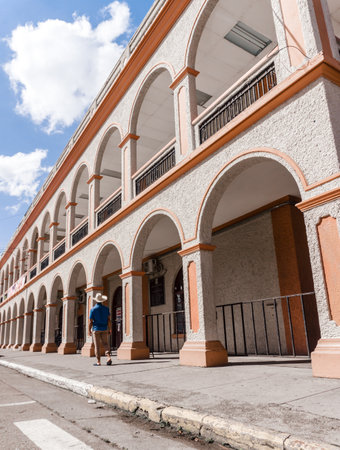 Tourist man with blue shirt and hat walking in front of the municipality of La Ceiba, Atlantida, Honduras.の写真素材