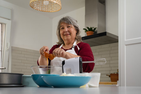 older woman with white hair making a strawberry cake in her home kitchen