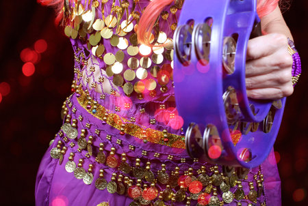 Belly Dancer wearing purple dance costume close up with colorful bokehの写真素材