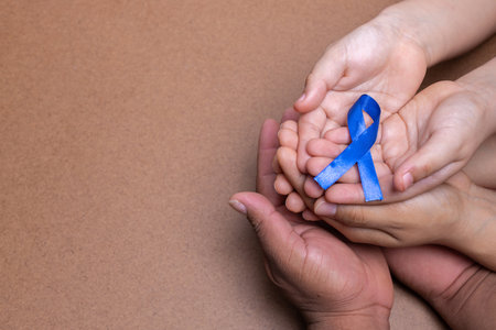 hands holding blue ribbon, thyroid cancer, chocolate backgroundの写真素材