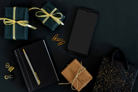 cardboard and black gift boxes with smart phone and bag, black Friday concept.の写真素材