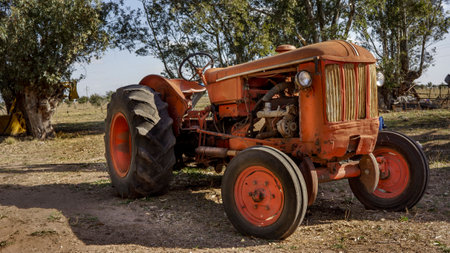 old rundown orange tractor parked outdoors