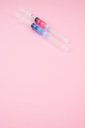 an isolated injection syringe on a pink background with text spaceの写真素材