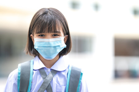 Cheerful Asian children student in student uniform back to school with medical facemask after COVID-19 pandemic. Back to School Concept Stock Photoの写真素材