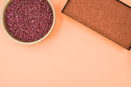 vases filled with terracotta color decorative sand on orange background with space for textの写真素材