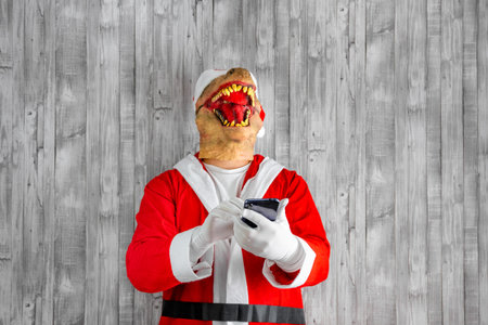 Santa Claus with dinosaur head chatting on cell phone