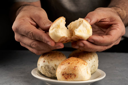 man's hand breaking piece of flavored bread