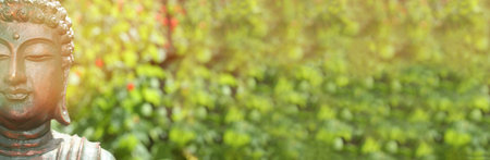 Buddha Statue Outdoors in Garden With Blurred Backgroundの写真素材