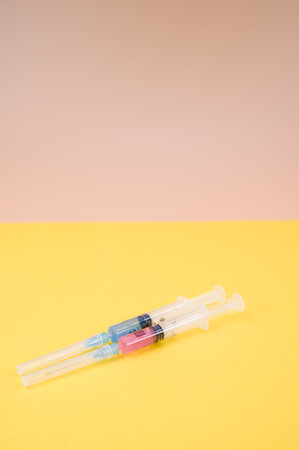 an isolated injection syringe on a yellow paper background with text spaceの写真素材