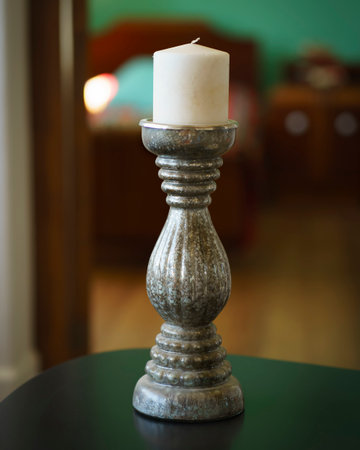 Old candlestick for a single candle on table and unfocused background. Vertical orientationの写真素材