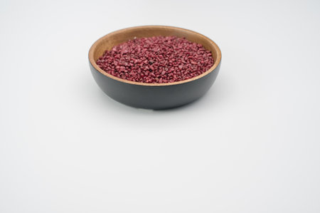 bowl filled with terracotta color decorative sand on white background with space for textの写真素材