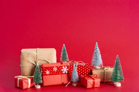 Christmas and new year concept. Christmas Gifts, Snowy Pine trees on red background.の写真素材