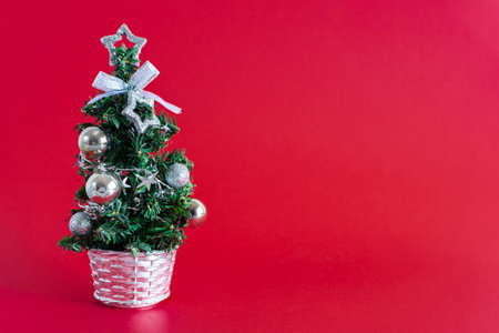 Christmas tree with silver ornaments on red background. Christmas and new year concept.の写真素材