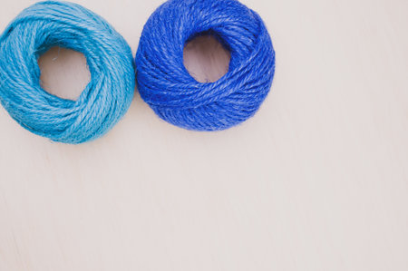 multicolor decoration yarns on a bright wooden background with copy space