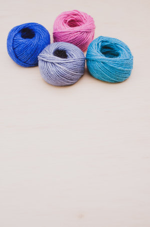 multicolor decoration yarns on a bright wooden background with copy space