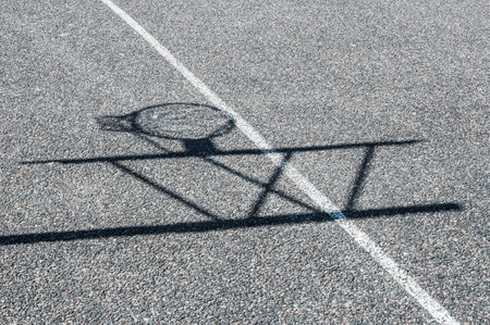 Shadow of basketball hoop on pavementの写真素材