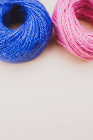 multicolor decoration yarns on a bright wooden background with copy space