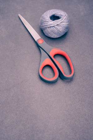 multicolor decoration yarns with scissors on a dark stonebackground with copy spaceの写真素材
