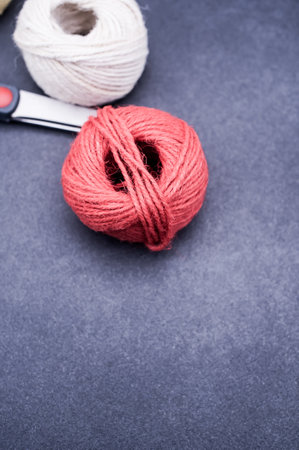 multicolor decoration yarns with scissors on a dark stone background with copy spaceの写真素材