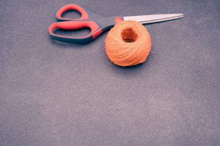 multicolor decoration yarns with scissors on a dark stonebackground with copy spaceの写真素材