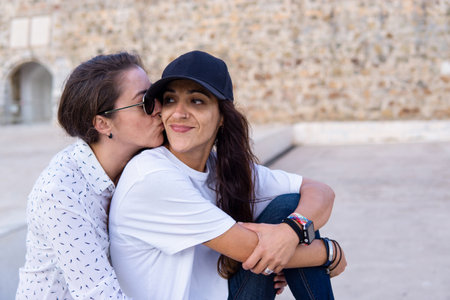 Couple of lesbian girls kissing sitting in a parkの写真素材