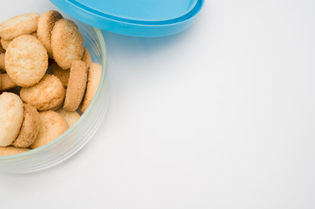 sweet and tasty coconut biscuits in a glass bowl on a white surface with copy spaceの写真素材