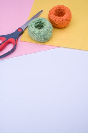 multicolor decoration yarns with scissors on a bright wooden background with copy space