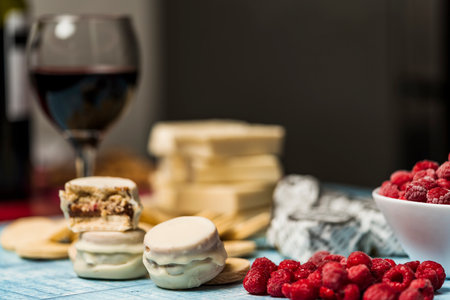 Close up view of Argentine homemade alfajores dipped in white chocolate and raspberries to a side. Concept of regional, traditional food.の写真素材