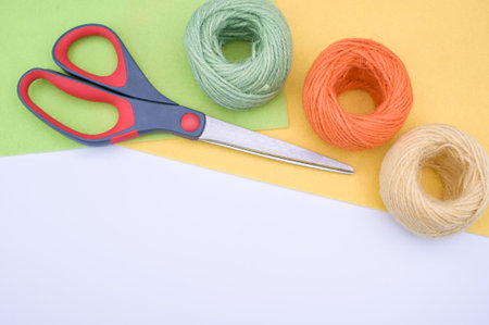 multicolor decoration yarns with scissors on a bright wooden background with copy space