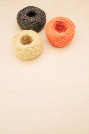 multicolor decoration yarns on a bright wooden background with copy space