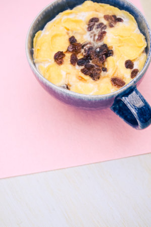 Fresh tasty breakfast with milk raisin and cereal with copy space on wooden tabletop