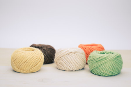 multicolor decoration yarns on a bright wooden background with copy space