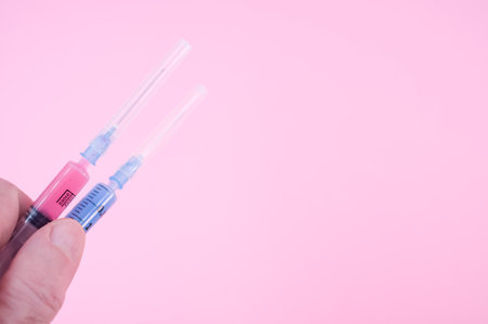 an isolated injection syringe on a pink background with text spaceの写真素材