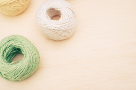 multicolor decoration yarns on a bright wooden background with copy space