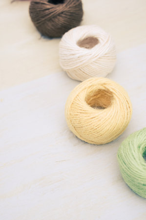 multicolor decoration yarns on a bright wooden background with copy space