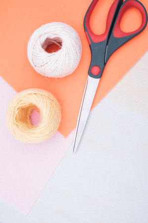 multicolor decoration yarns with scissors on a bright wooden background with copy space