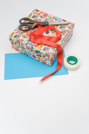 a closed white cardboard decorated box with stationery and letter paper on white background with...