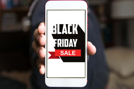 Hand holding cellphone with black friday text . Concept of sales, online shopping, and e-commerce.の写真素材