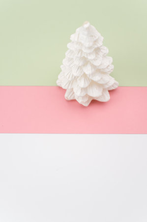 Christmas ornamental background with fir trees on a pink and green surface with copy spaceの写真素材