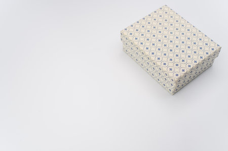 a closed white paperboard decorated box on white background with text space
