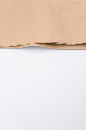 natural food paper bag folded on a white surface with text space