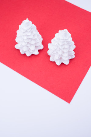 Christmas ornamental background with fir trees on a red and white surface with copy space