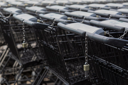 Close-up of shopping carts in several rows fading to blurry background