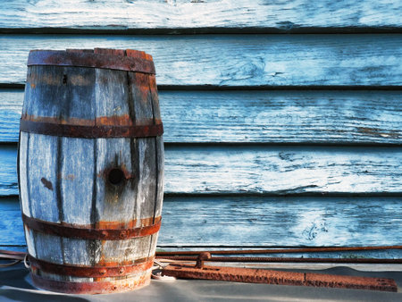 old Oak barrel in front of a painted blue wooden wallの写真素材
