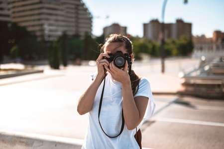 Young girl on vacation in the city taking pictures with an analog camera
