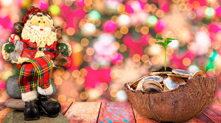 Christmas theme with Santa Claus snowman and half coconut shell full of coins.の写真素材